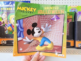 hand holding a mickey mouse haunted halloween book