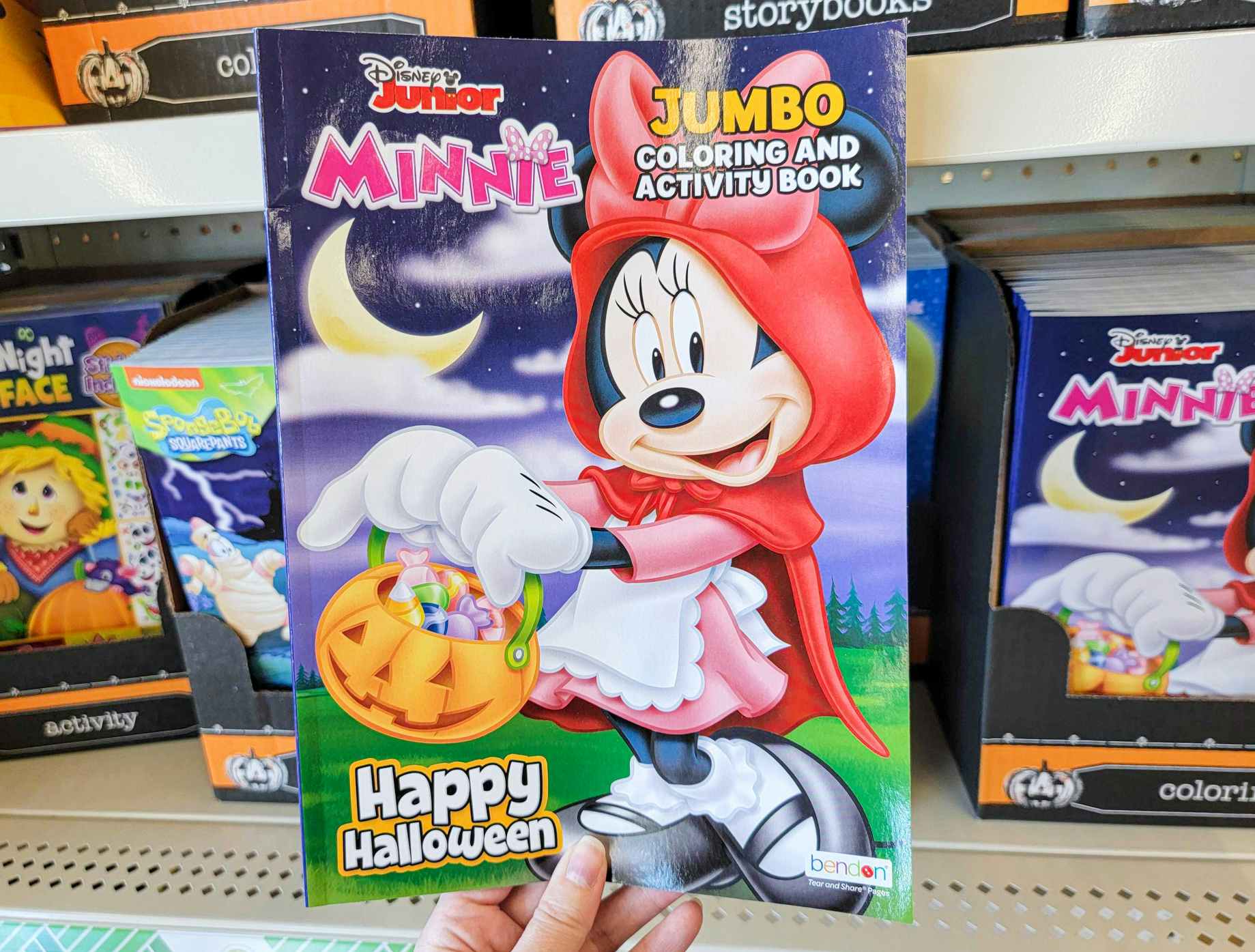 hand holding a minnie mouse halloween coloring and activity book