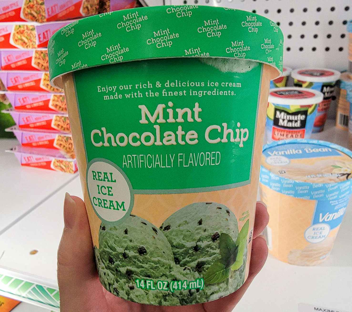 hand holding a tub of mint chocolate chip ice cream