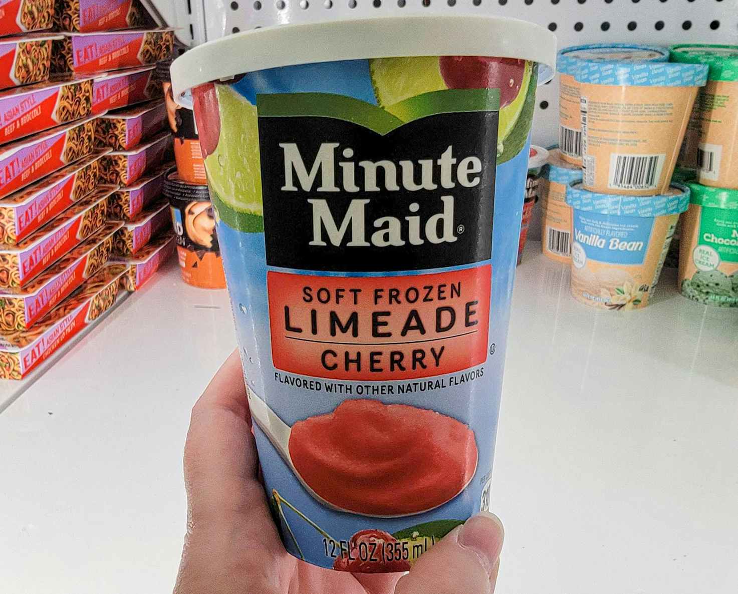 hand holding a tub of minute maid frozen cherry limeade dessert