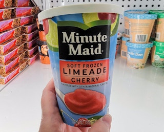 hand holding a tub of minute maid frozen cherry limeade dessert