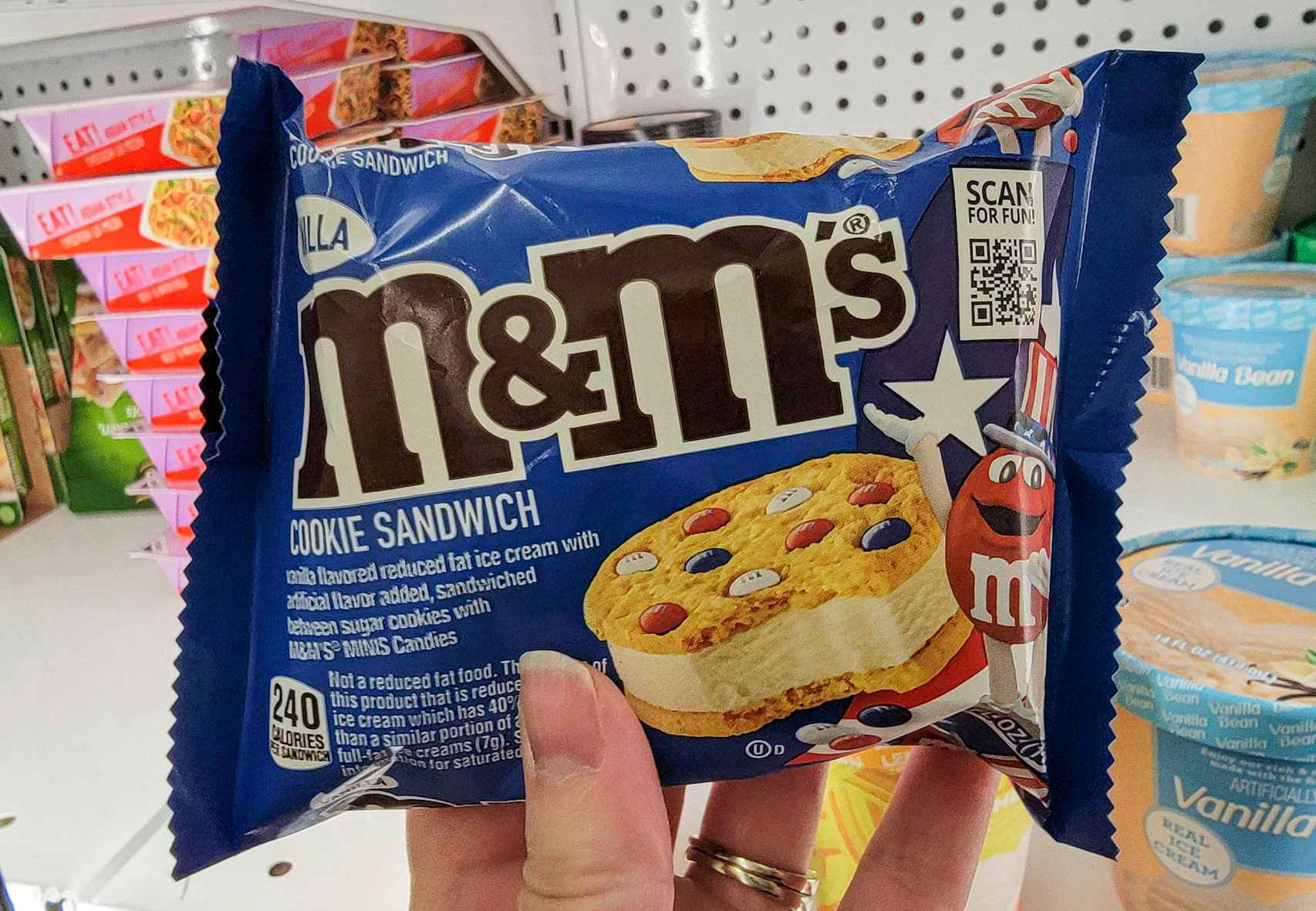 hand holding an m&m cookie ice cream sandwich