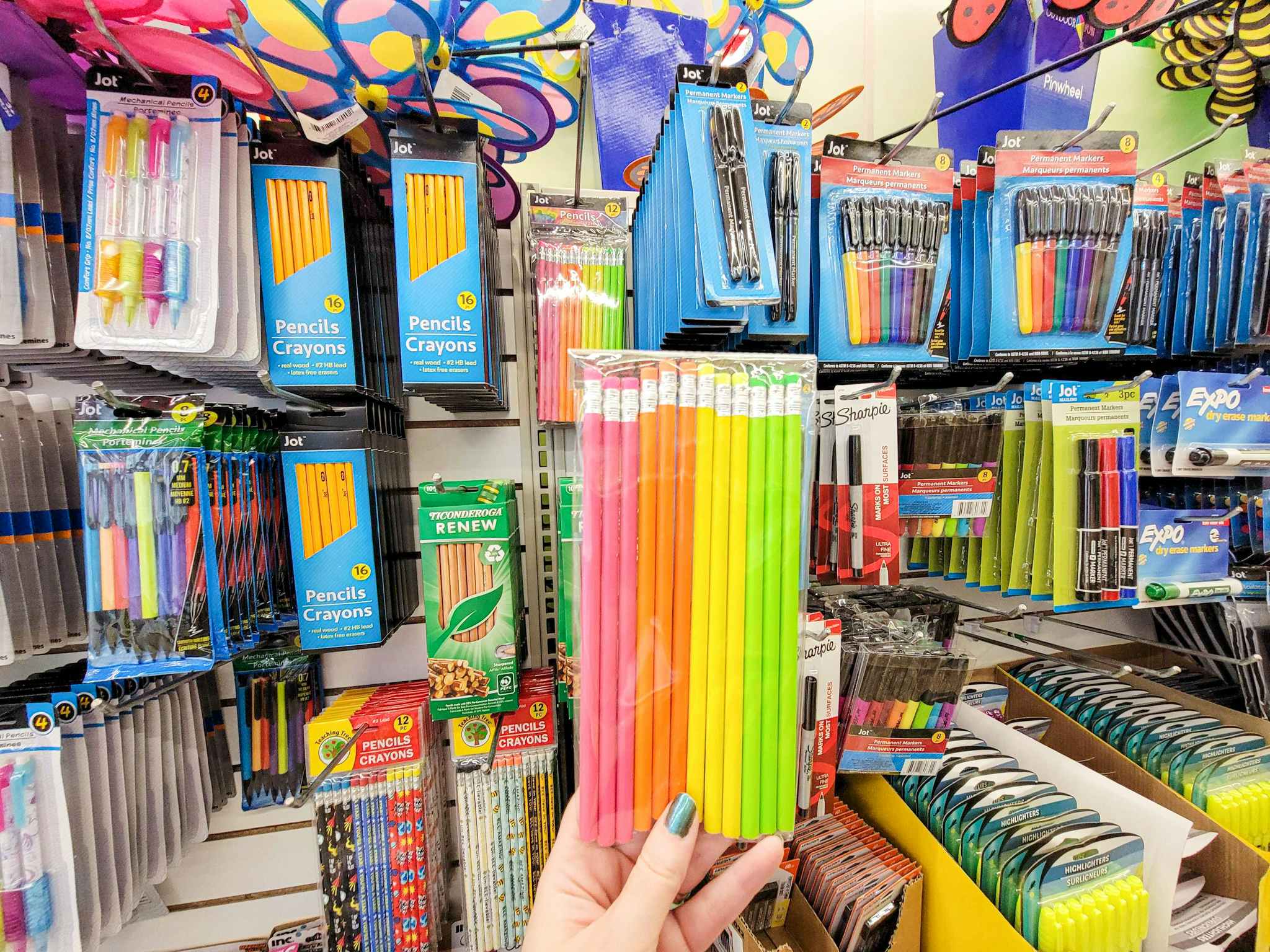 hand holding a pack of neon pencils