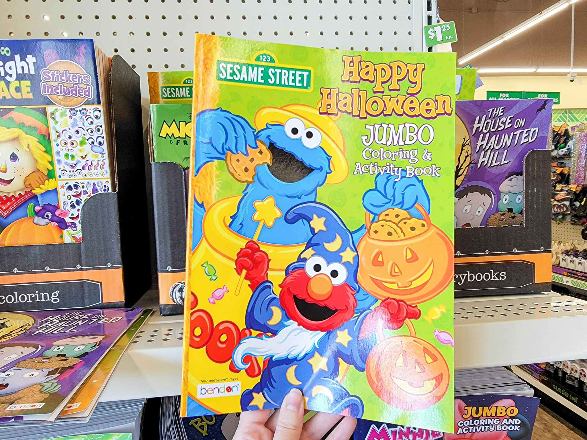 hand holding a sesame street activity and coloring book
