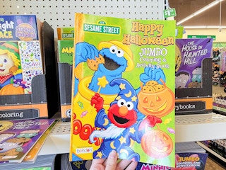 hand holding a sesame street activity and coloring book