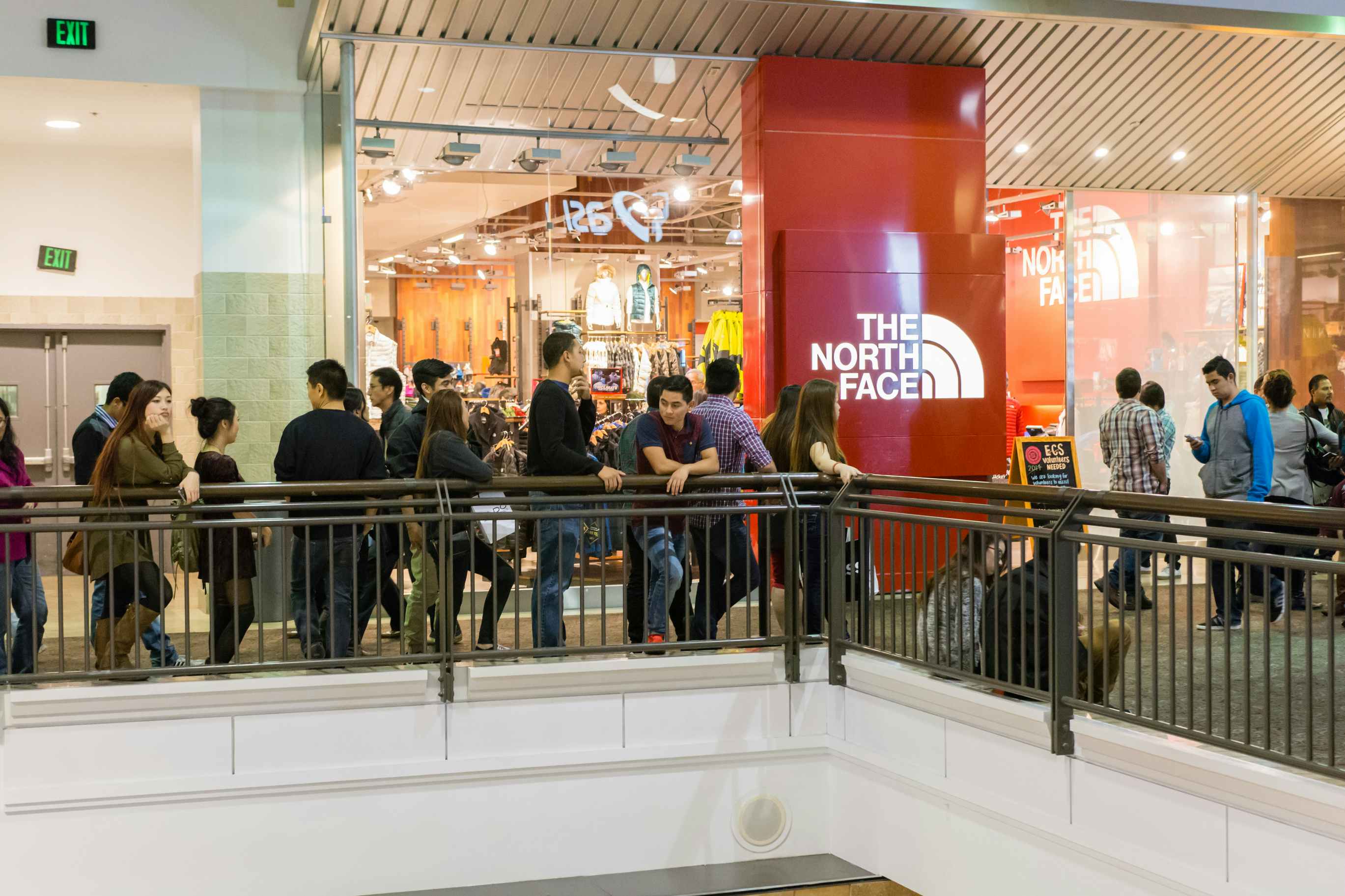 a crowd of people outside a north face store in mall 
