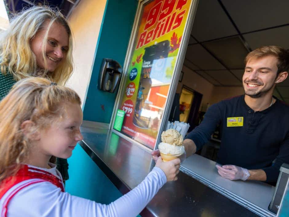 A little girl getting an ice cream cone from a stand at Dutch Wonderland.