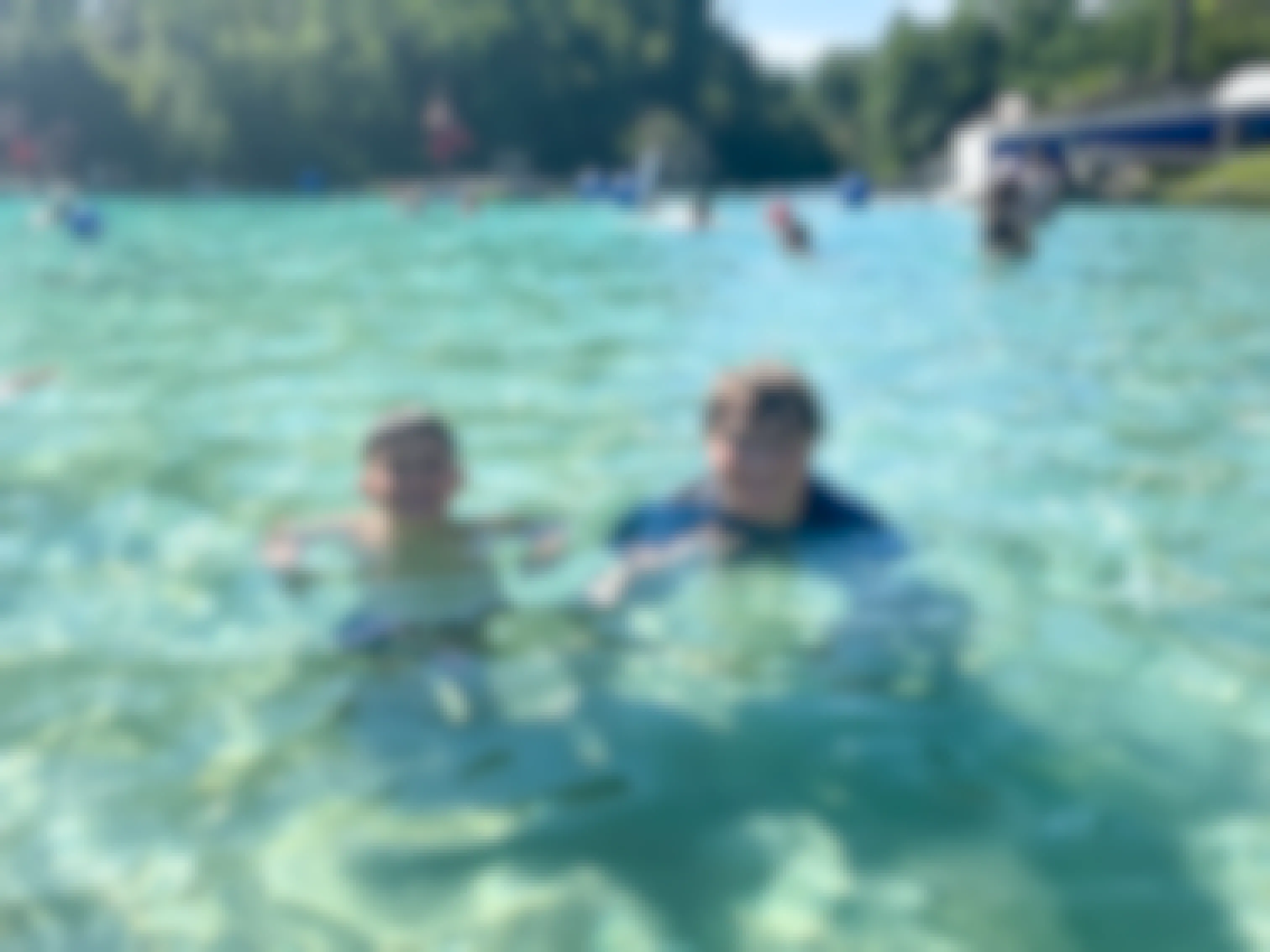Two boys swimming in crystal blue water