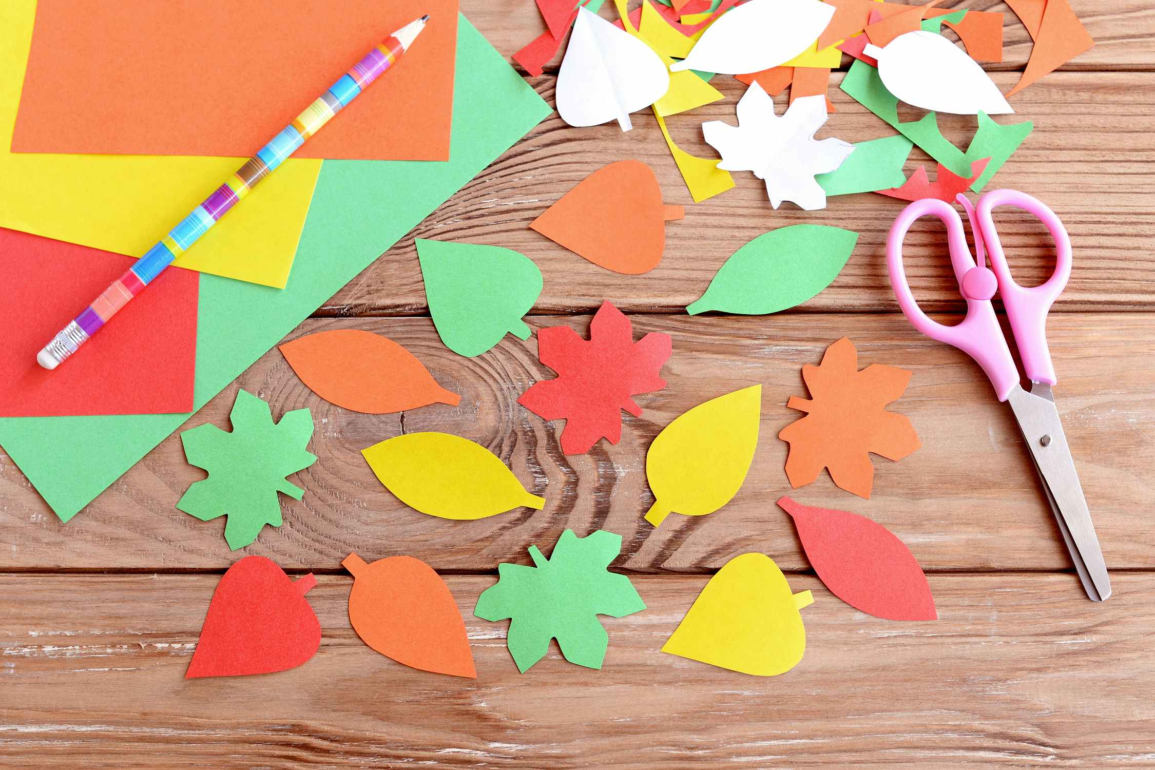 cut-out construction paper leaves and scissors on table