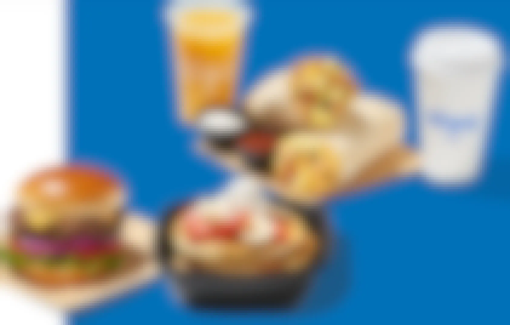 a group of food from flip'd by ihop set on a blue background. 