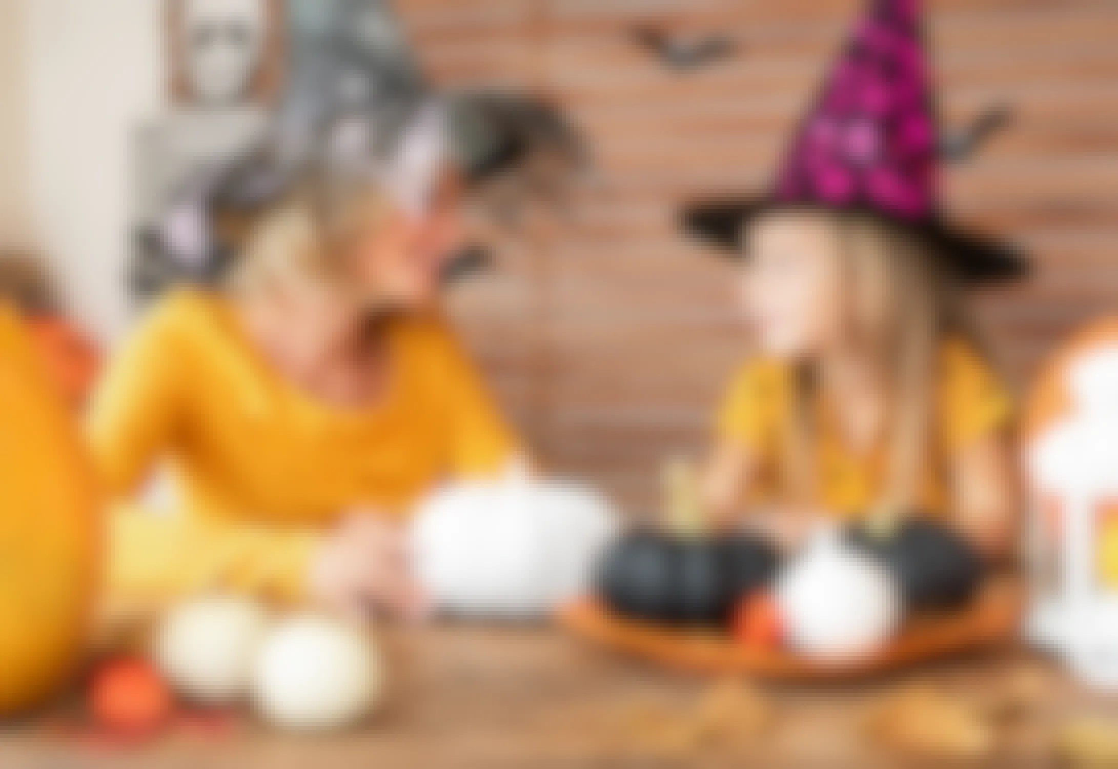 woman and daughter dressed in Halloween witch hats with pumpkins