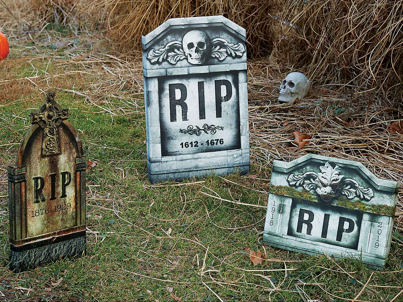 Three fake gravestones decorating a front lawn.
