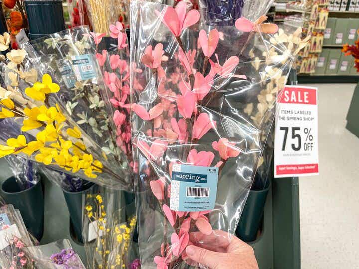 someone holding up a bouquet of fake floral at hobby lobby