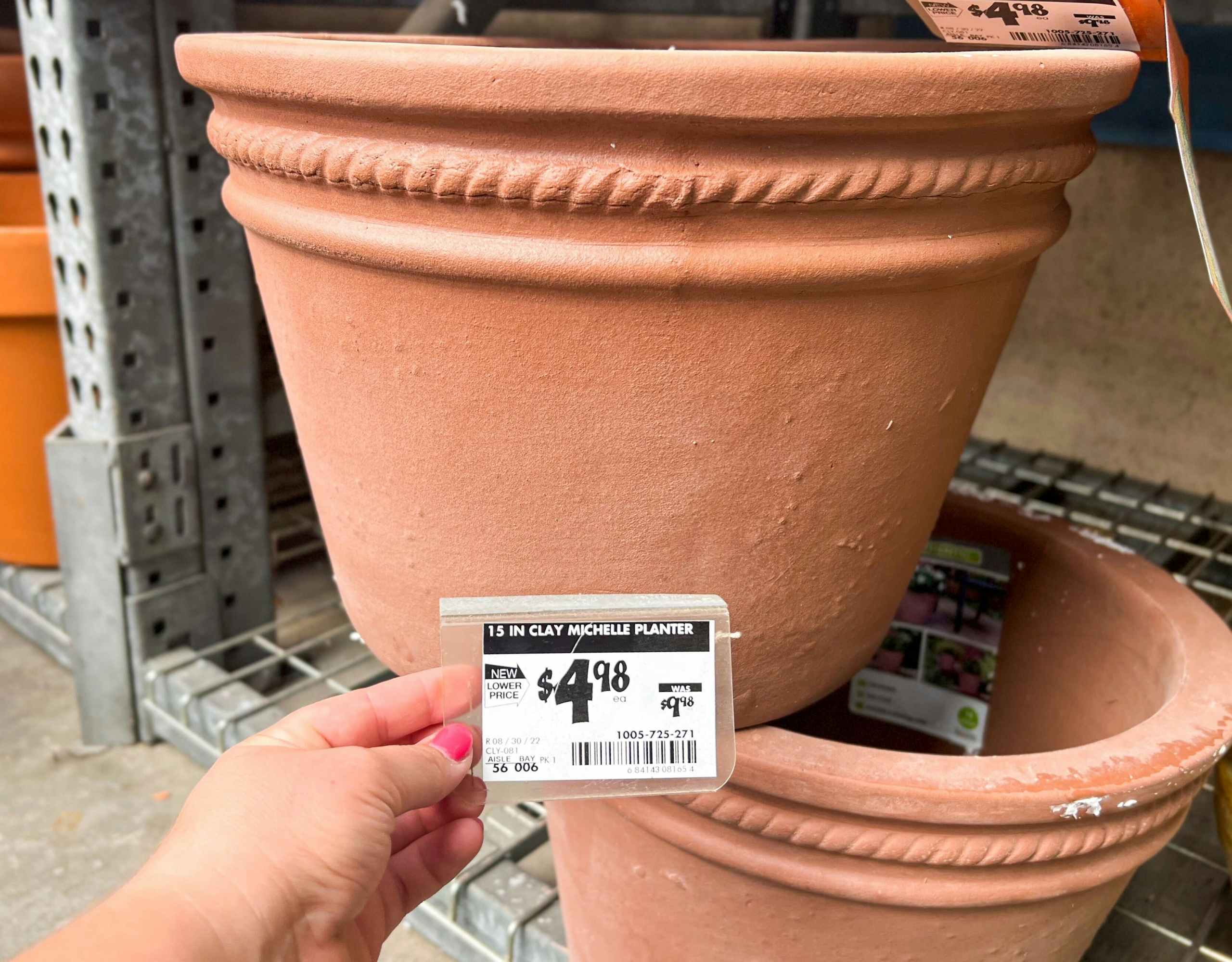 hand holding price tag on southern patio large terra cotta planter at home depot