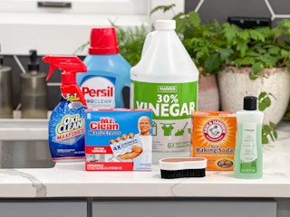 Household cleaning supplies on a counter next to a sink.