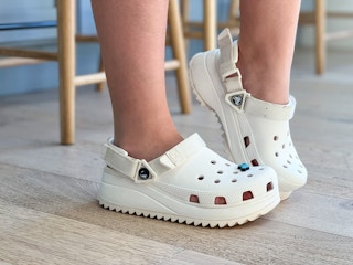 A person wearing Crocs on their feet.