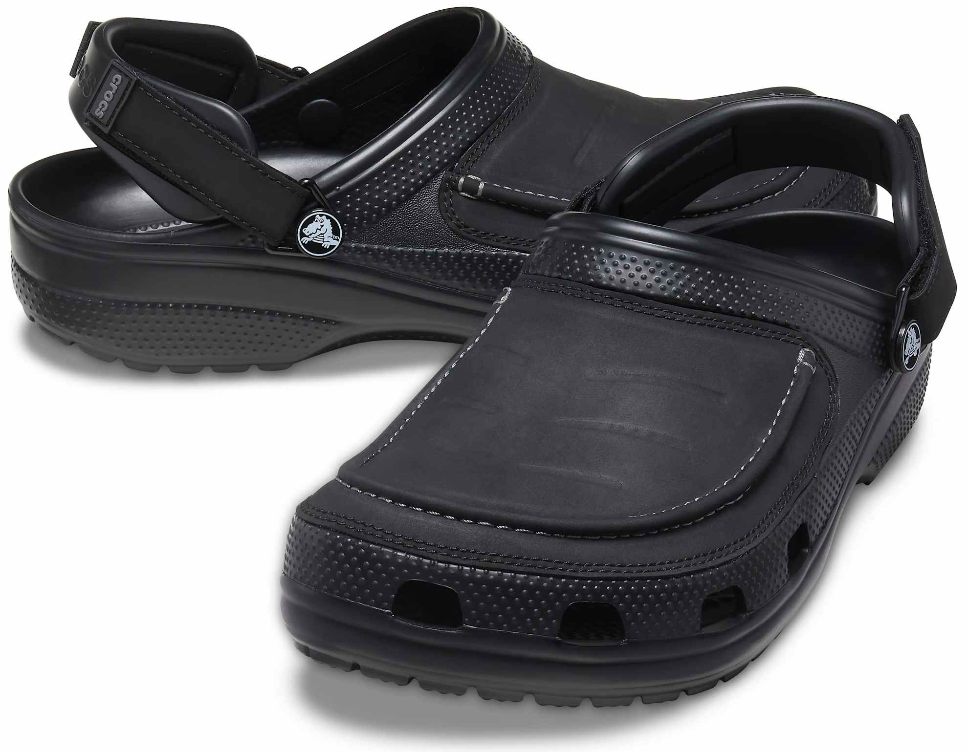 A pair of men's patent leather Crocs clogs on a white background