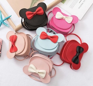 variety of Bowknot Shoulder Bag With Cartoon Mouse Ears in different colors laying on a table