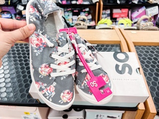 someone holding a pair of so womens redwood sneakers