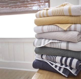 a stack of solid and striped bath towels