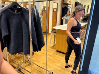 model in dressing room trying on new top