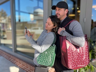 couple outside lululemon store on cell phone holding bags