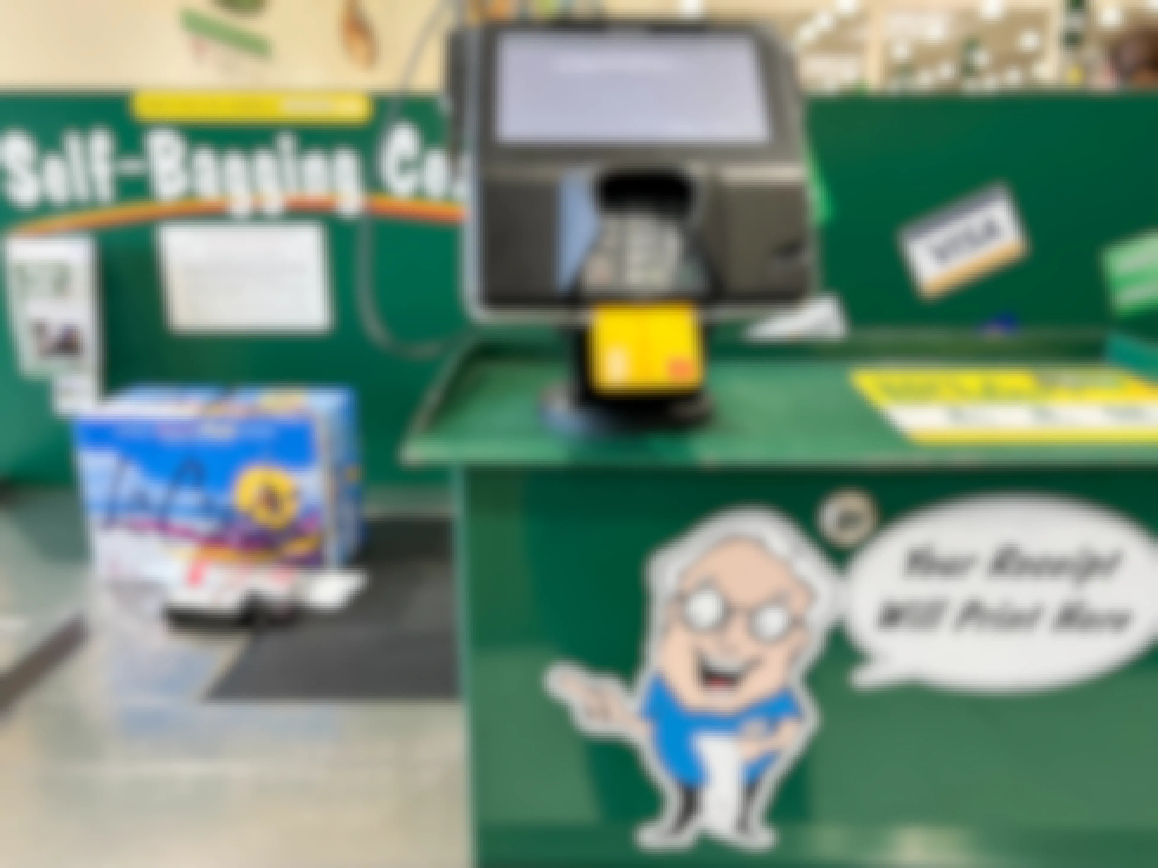 A credit card in a point of sale machine in the checkout lane at Menards with products on the conveyer belt.