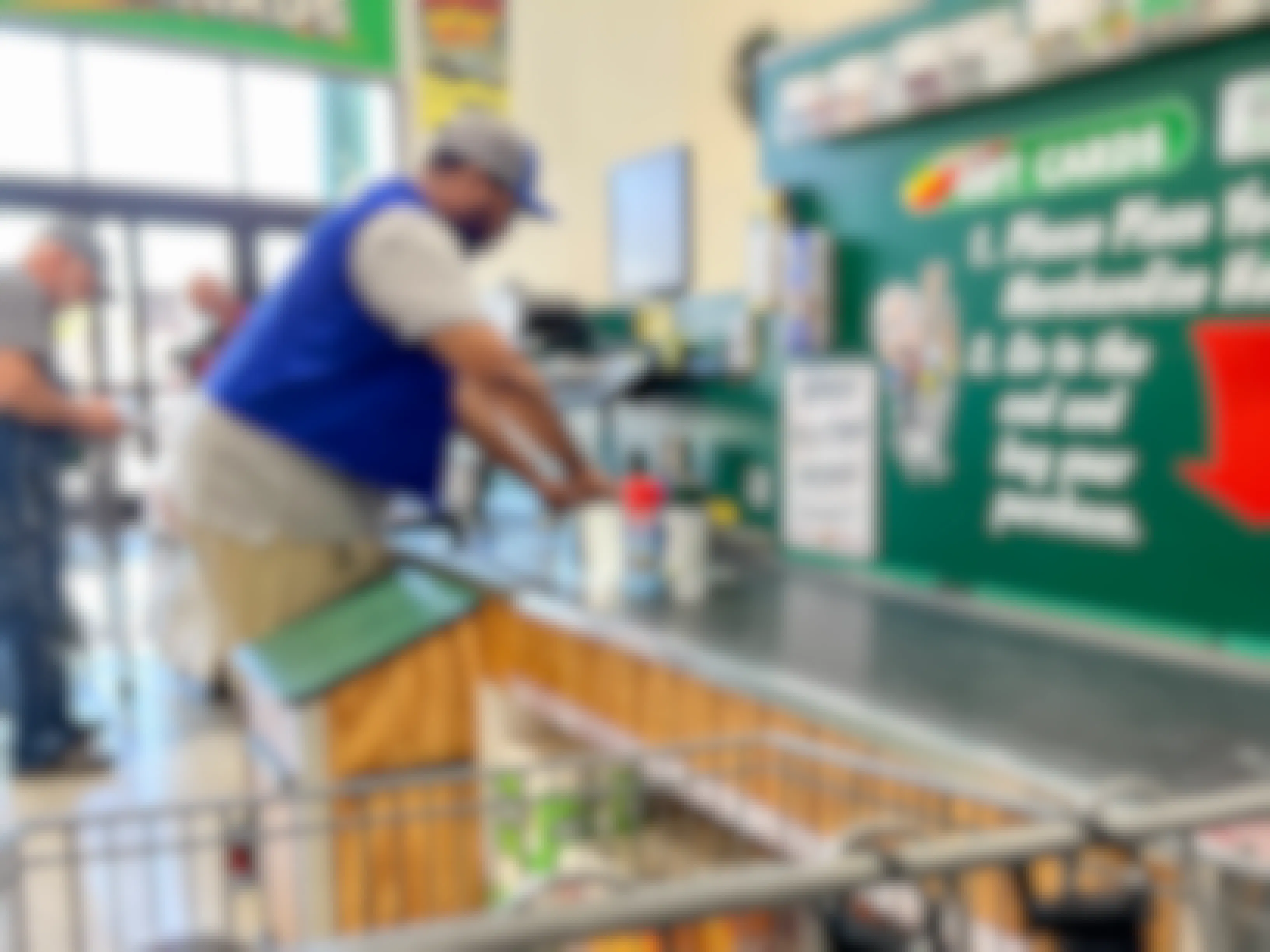 A Menards employee scanning items at the checkout lane.