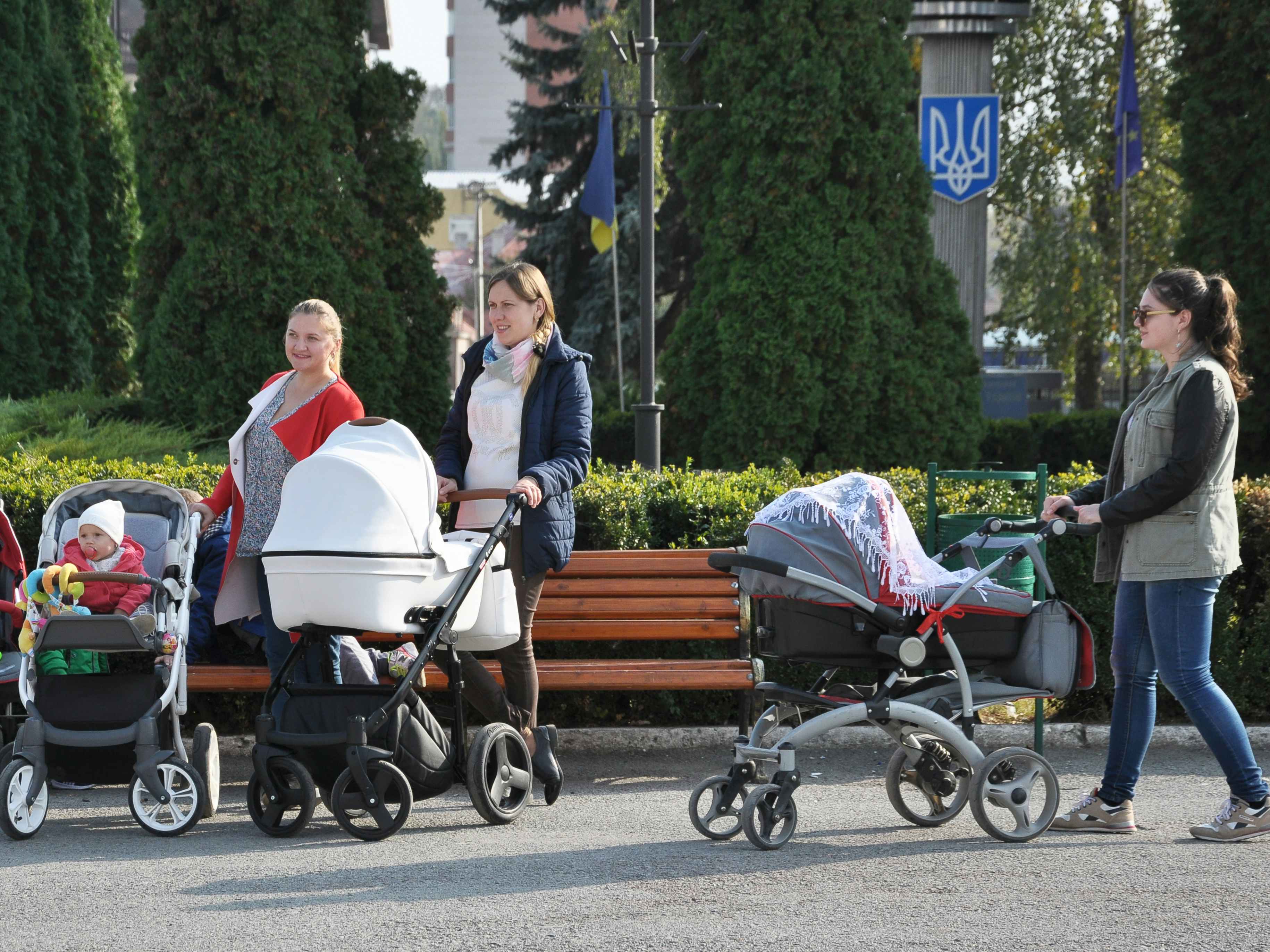 Mothers pushing strollers while visiting an amusement park.