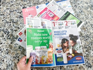 hand holding newspaper coupons