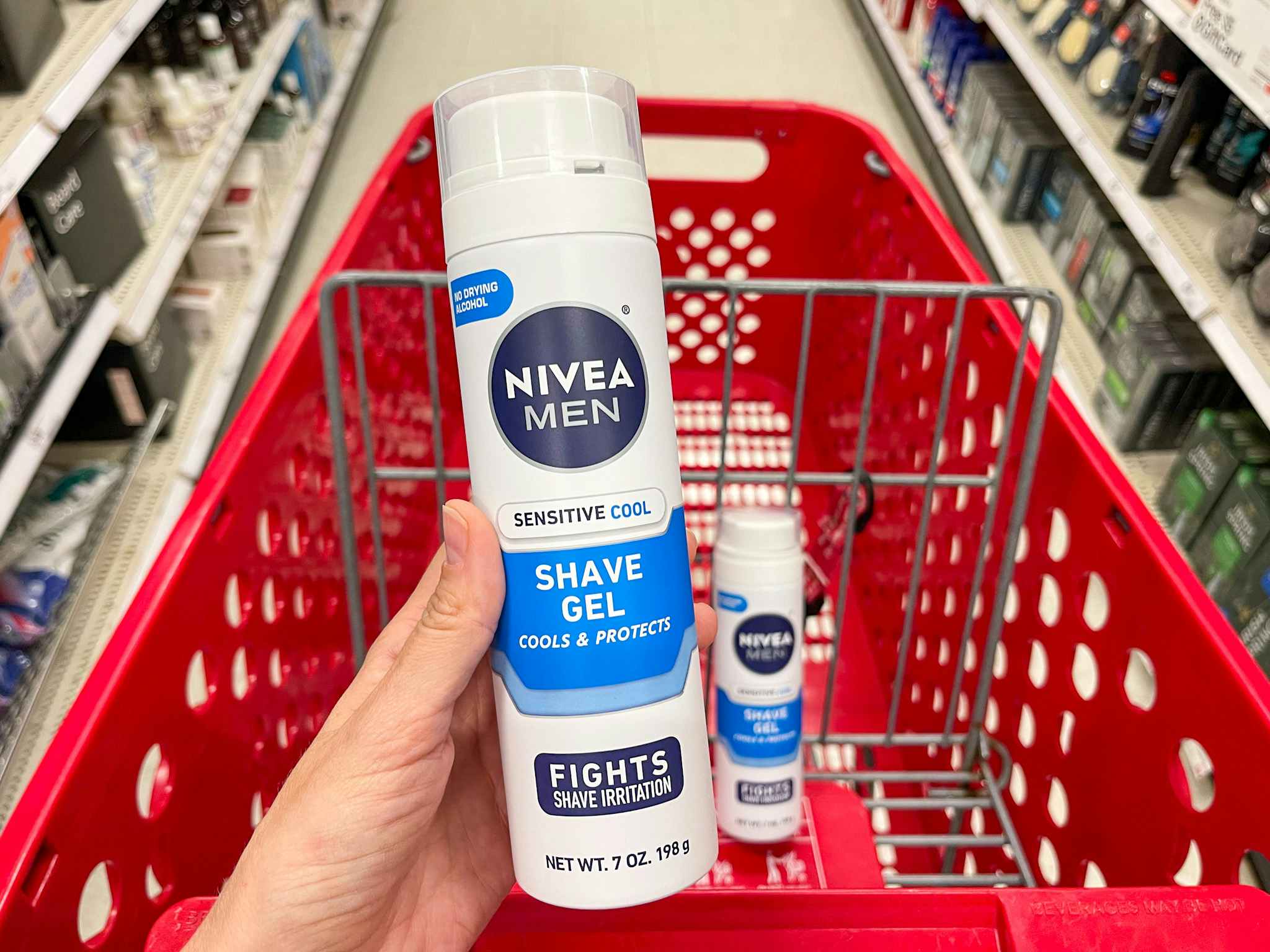 A can of Nivea Men sensitive cool shave gel held out in front of a shopping cart with another Nivea men sensitive cool shave cream.