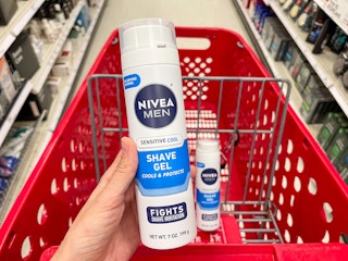 A can of Nivea Men sensitive cool shave gel held out in front of a shopping cart with another Nivea men sensitive cool shave cream.