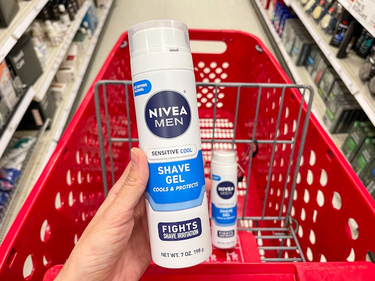 A can of Nivea Men sensitive cool shave gel held out in front of a shopping cart with another Nivea men sensitive cool shave cream.