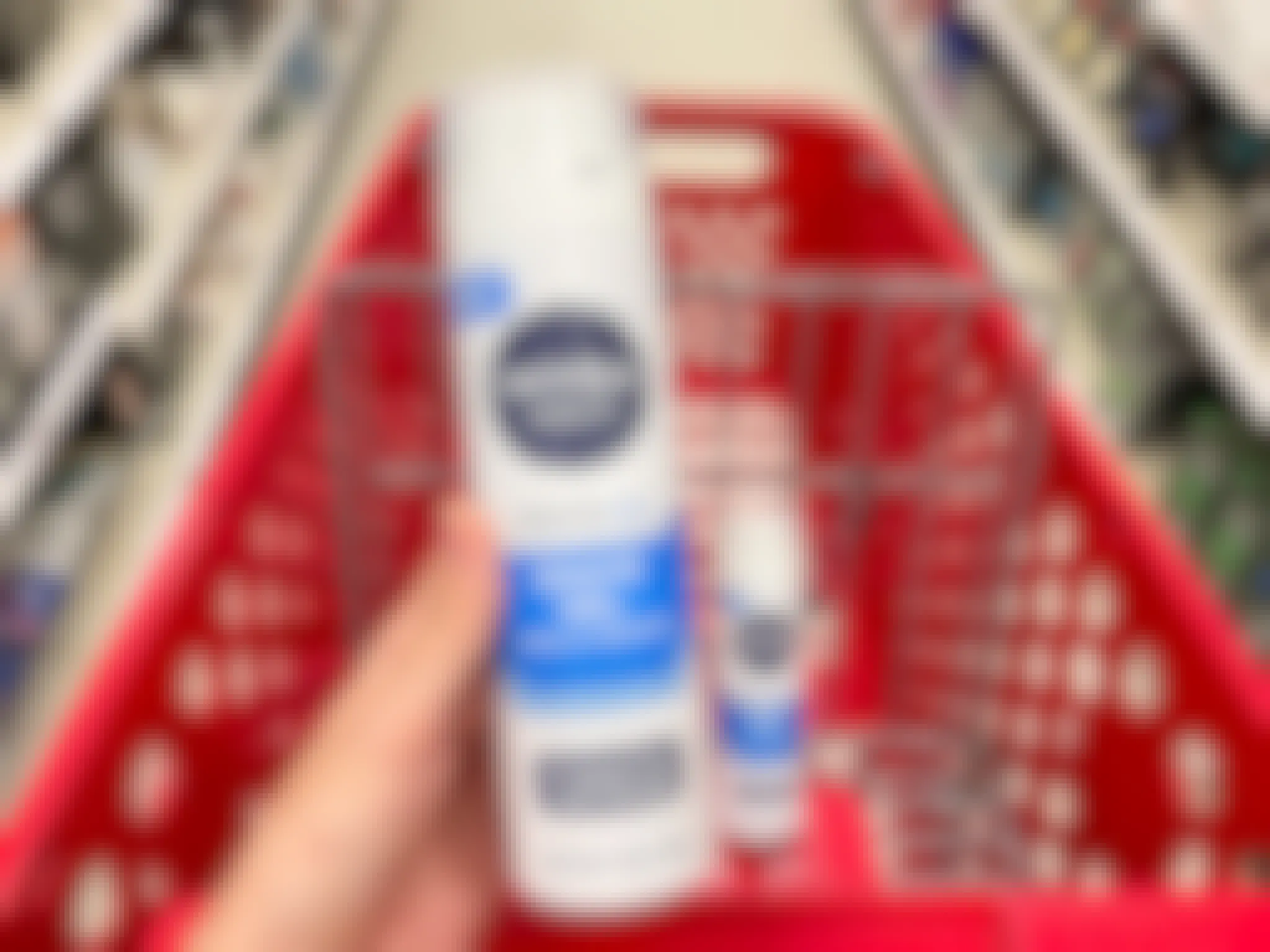 A can of Nivea Men sensitive cool shave gel held out in front of a shopping cart with another Nivea men sensitive cool shave cream.