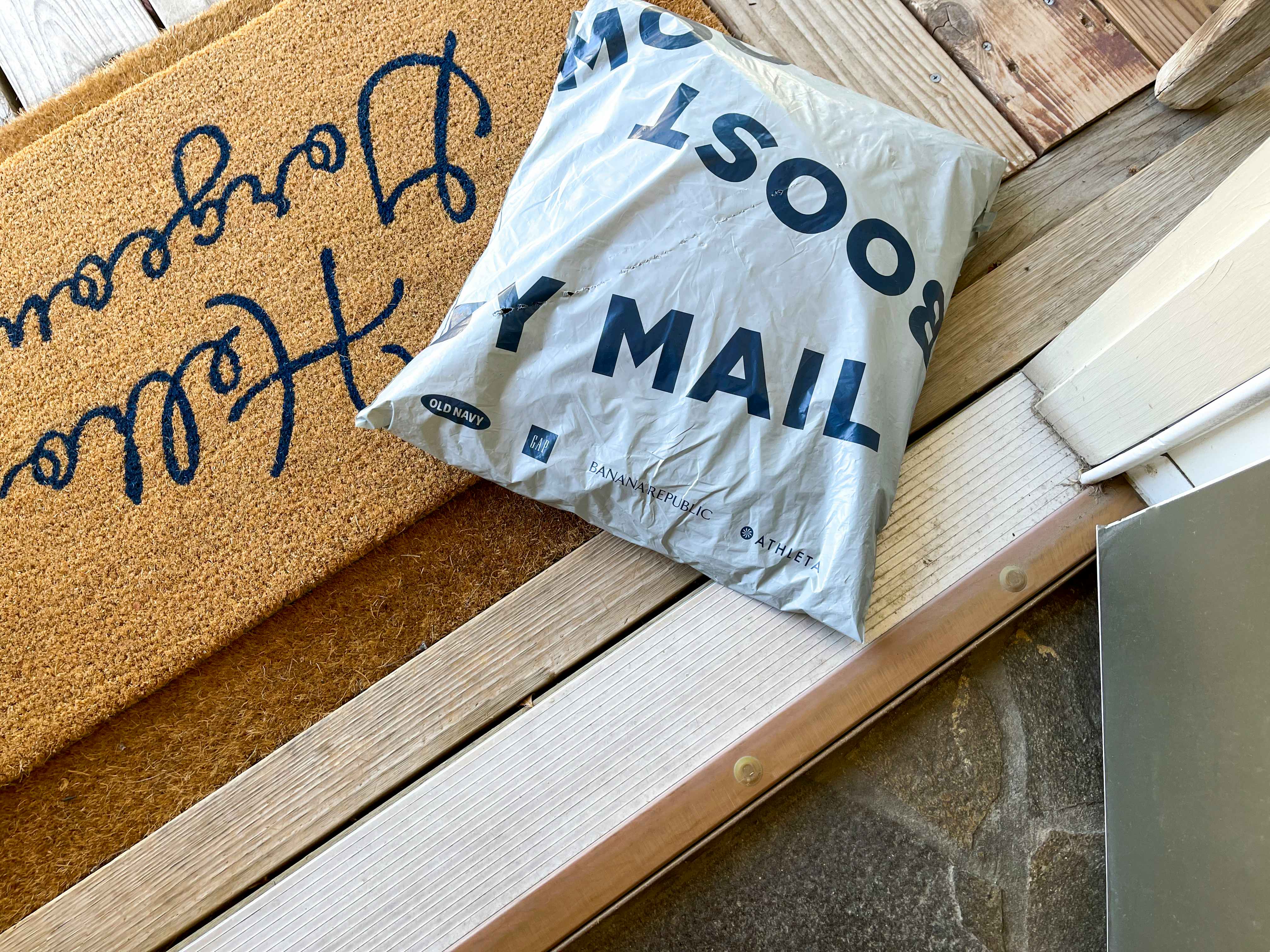 A plastic delivery bag sitting on a doormat.