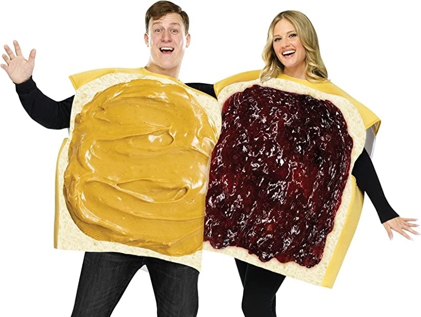 A couple dressed as slices of bread with peanut butter and jelly spread.