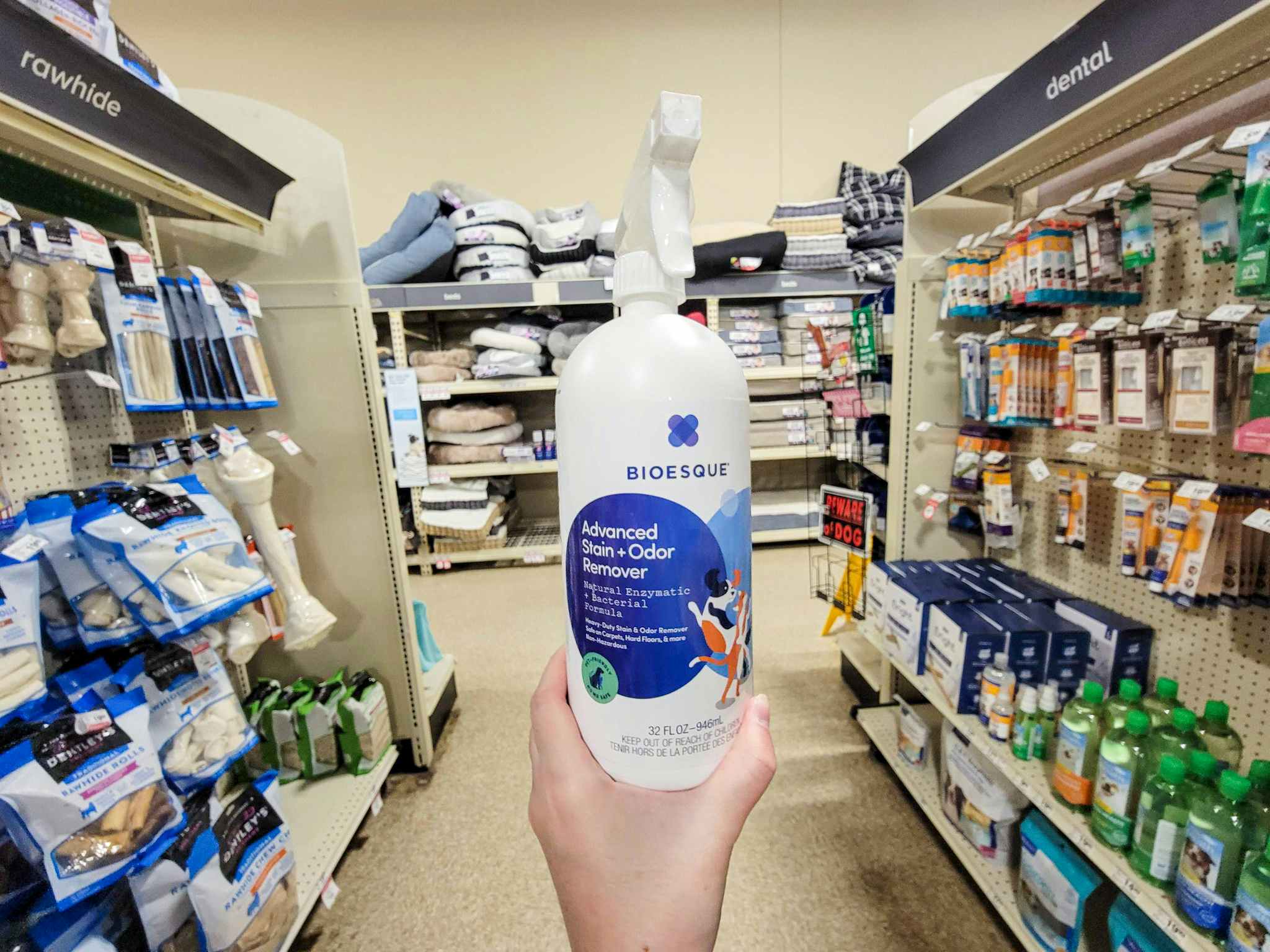 hand holding a bottle of bioesque advanced stain & odor remover in an aisle
