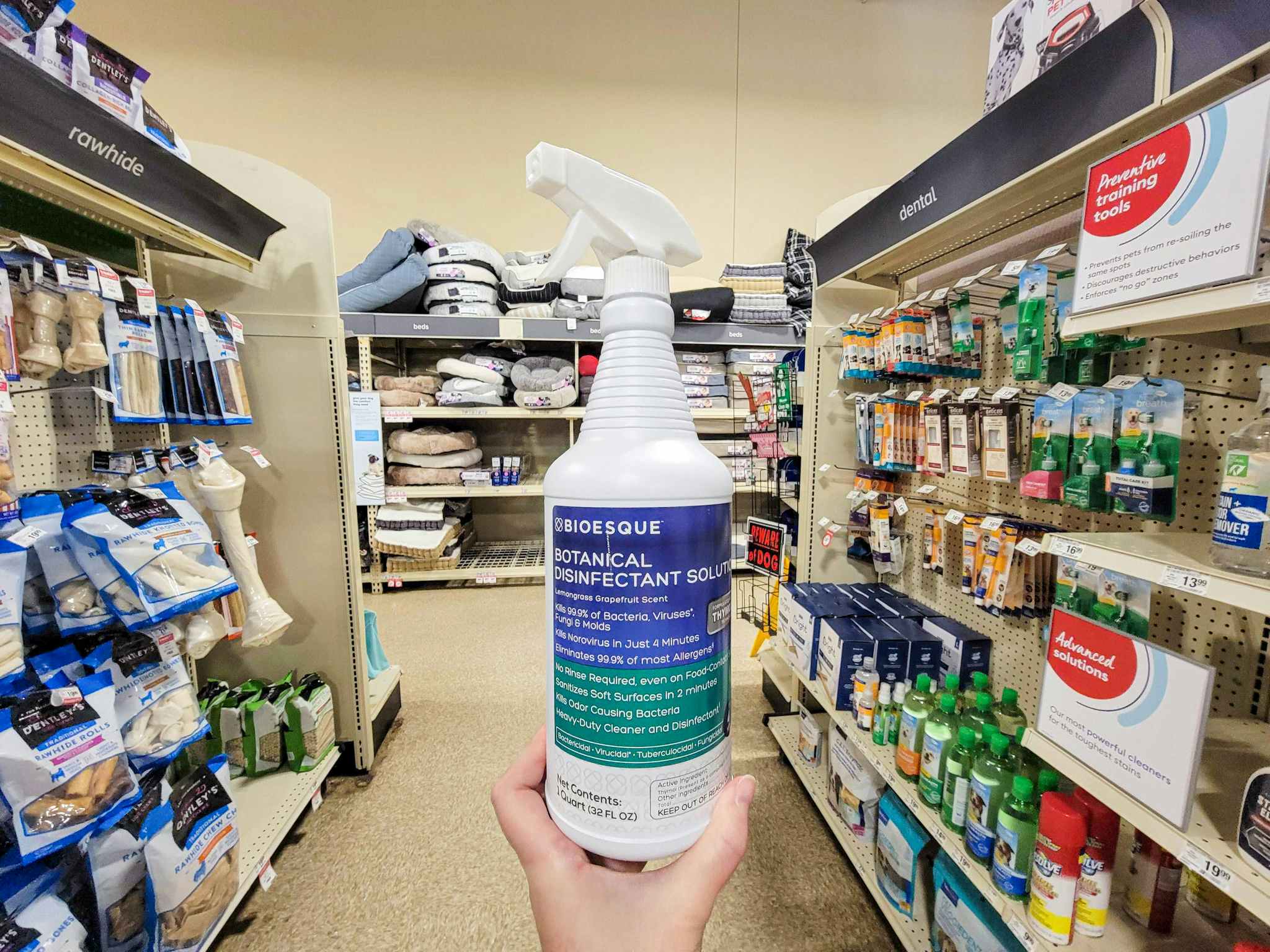 hand holding a bottle of bioesque botanical disinfectant solution spray in an aisle