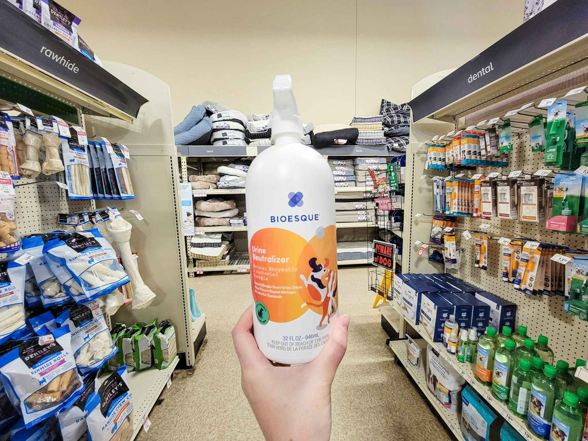 hand holding a bottle of bioesque urine neutralizer spray in an aisle