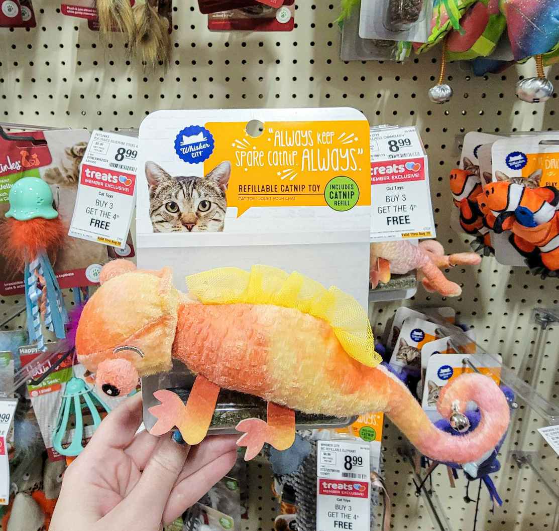 hand holding a catnip toy lizard