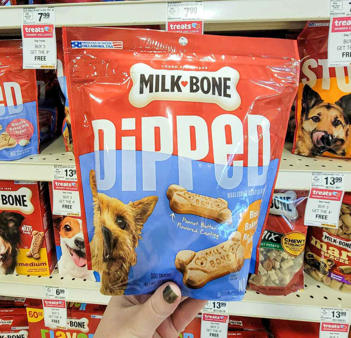 hand holding a bag of milk bone dipped dog treats