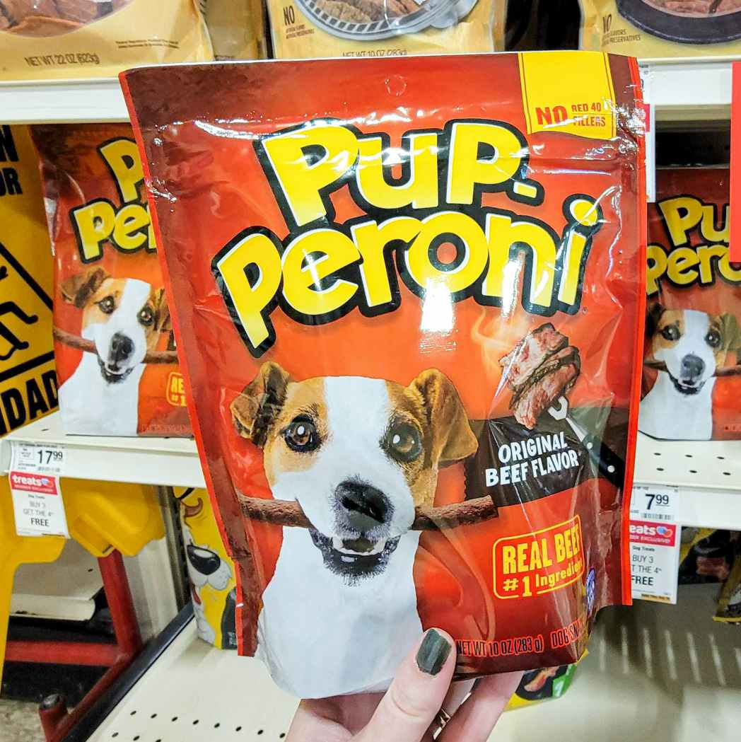 hand holding a bag of pup peroni dog treats