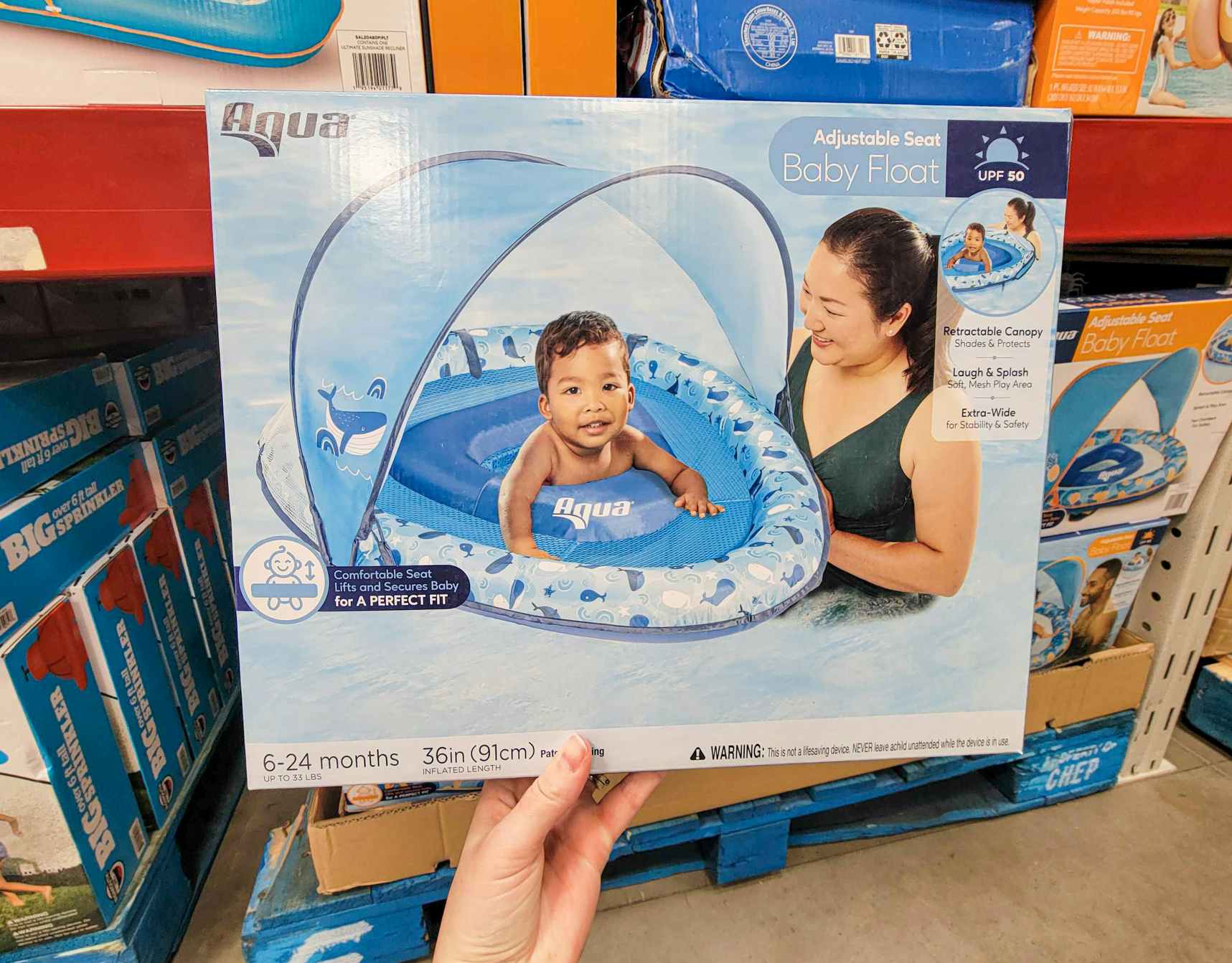 hand holding a box with a baby pool float 