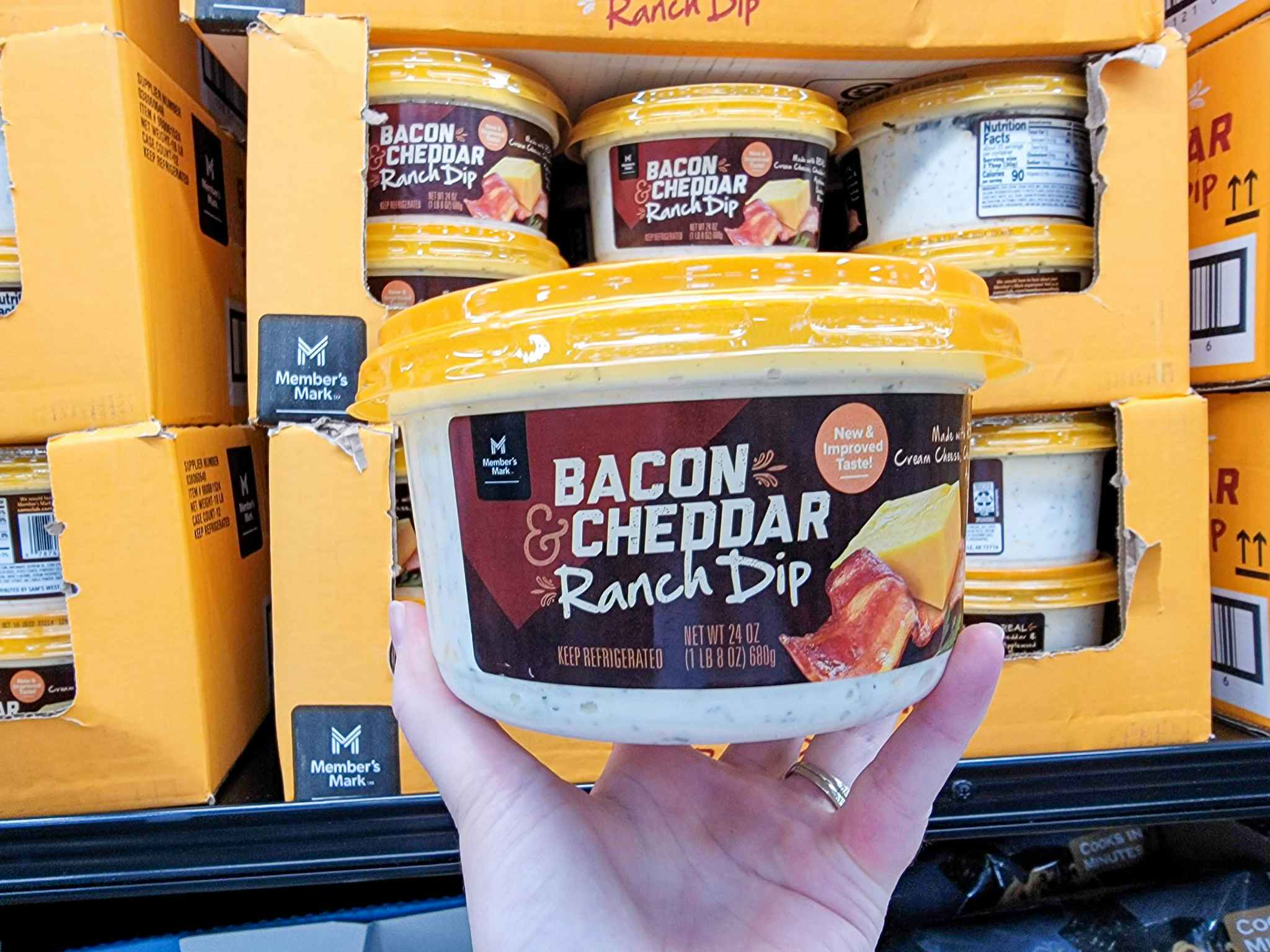 hand holding a tub of bacon cheddar ranch dip
