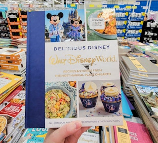 hand holding a disney parks cookbook