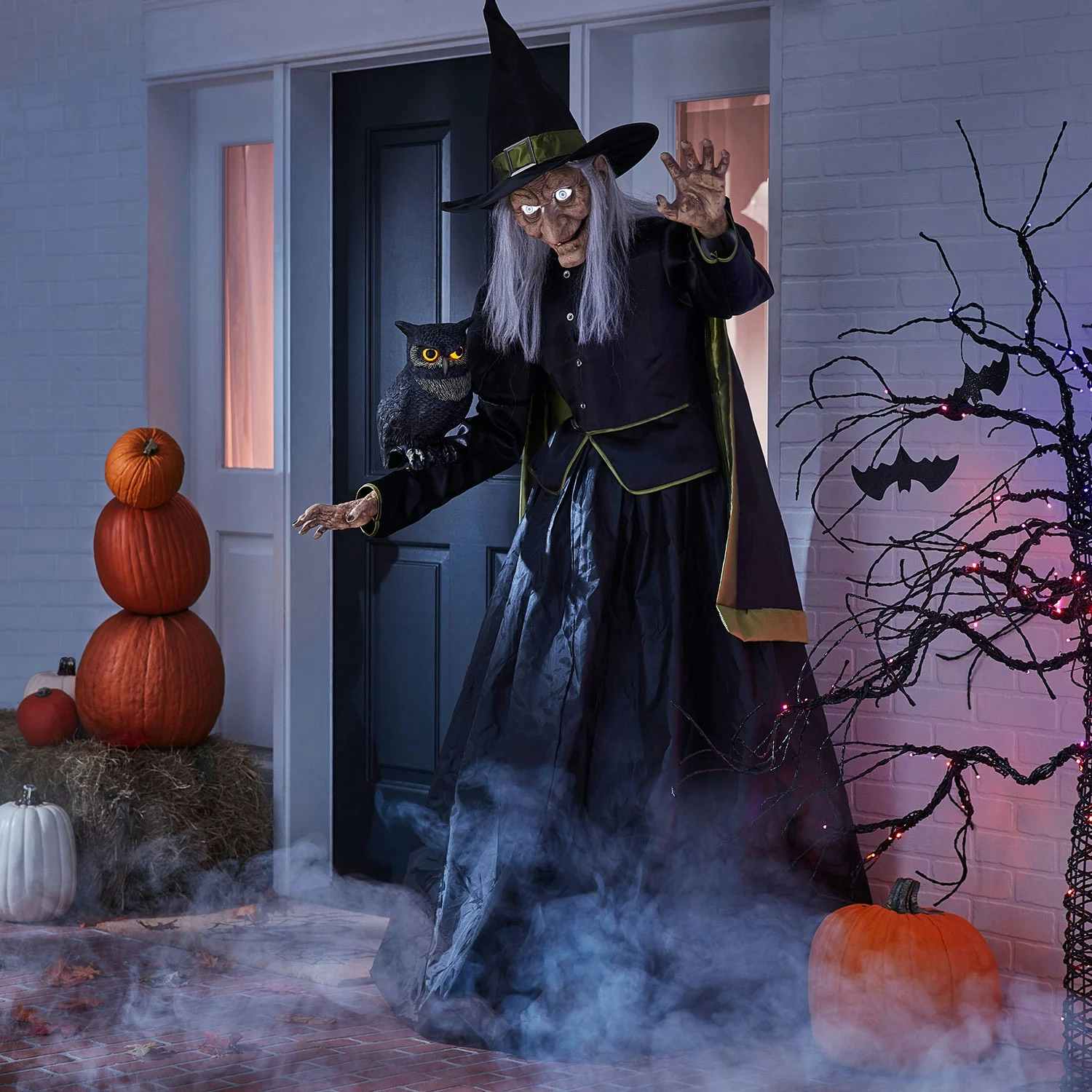 tall animated witch displayed in front of a house for halloween