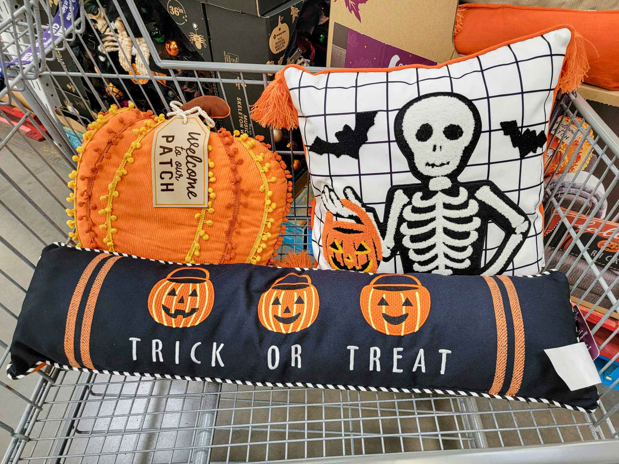 3 halloween themed pillows in a cart