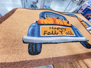 doormat with a blue truck on it that says happy fall y'all with pumpkins in it