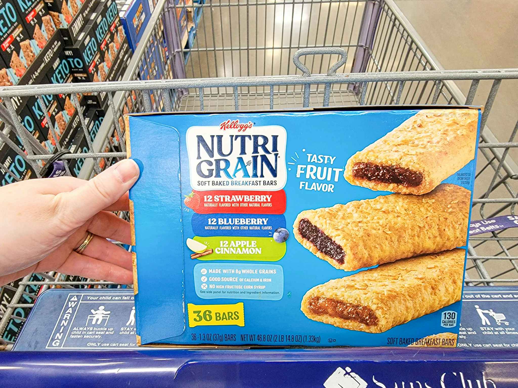 hand holding a box of 36 kelloggs nutri grain bars in a cart