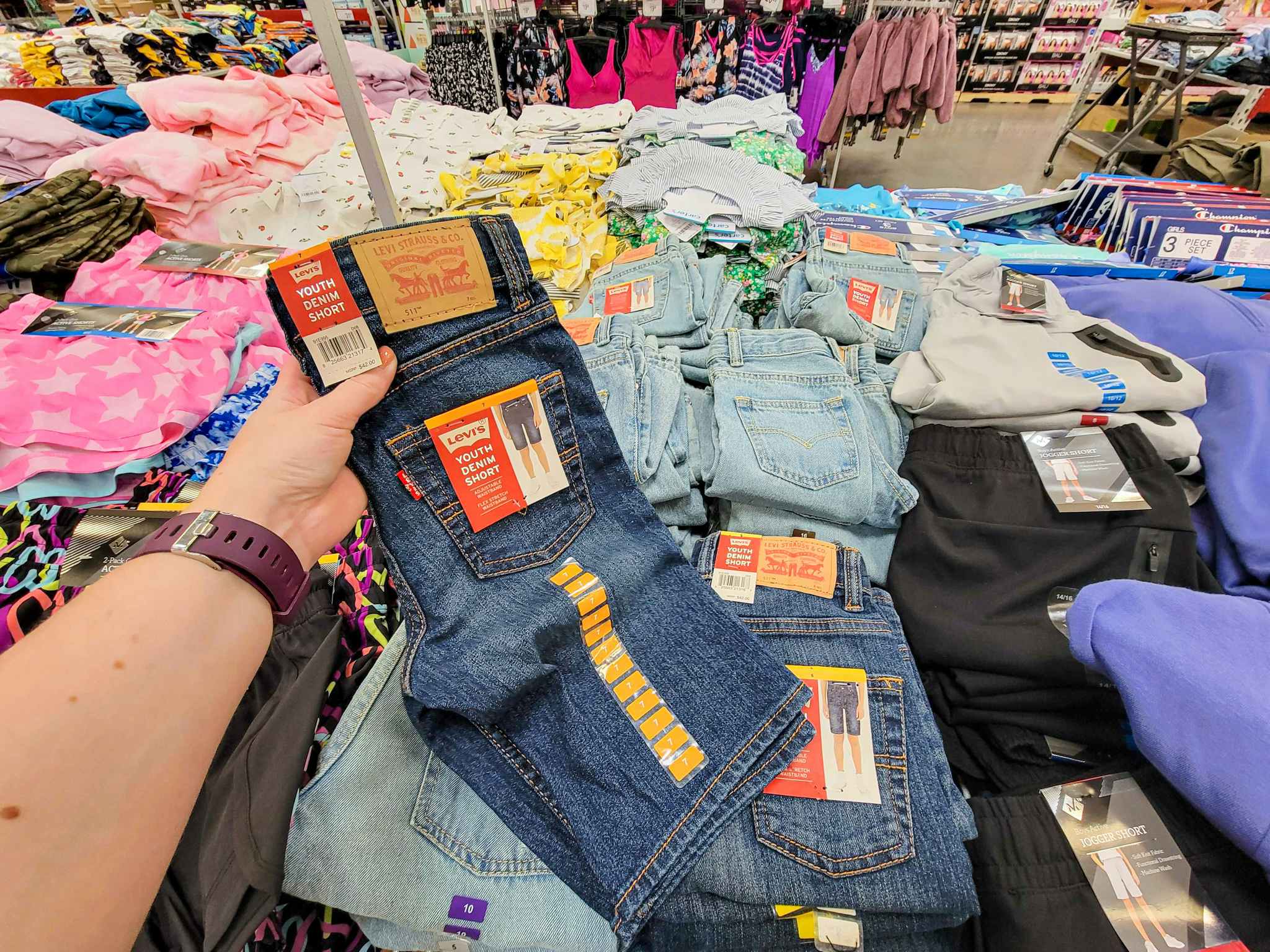 hand holding up a pair of kids denim levi shorts